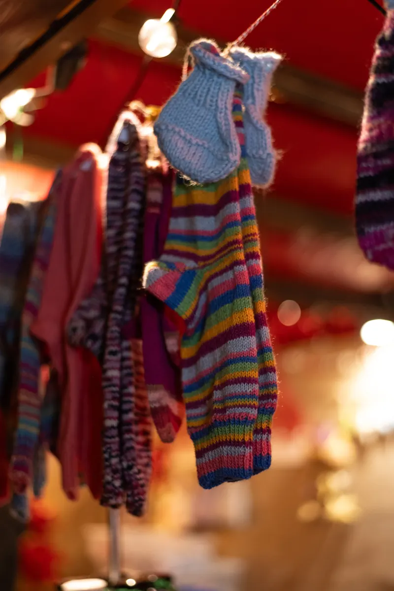 Handgestrickte Socken und Babyschuhe an einer Leine