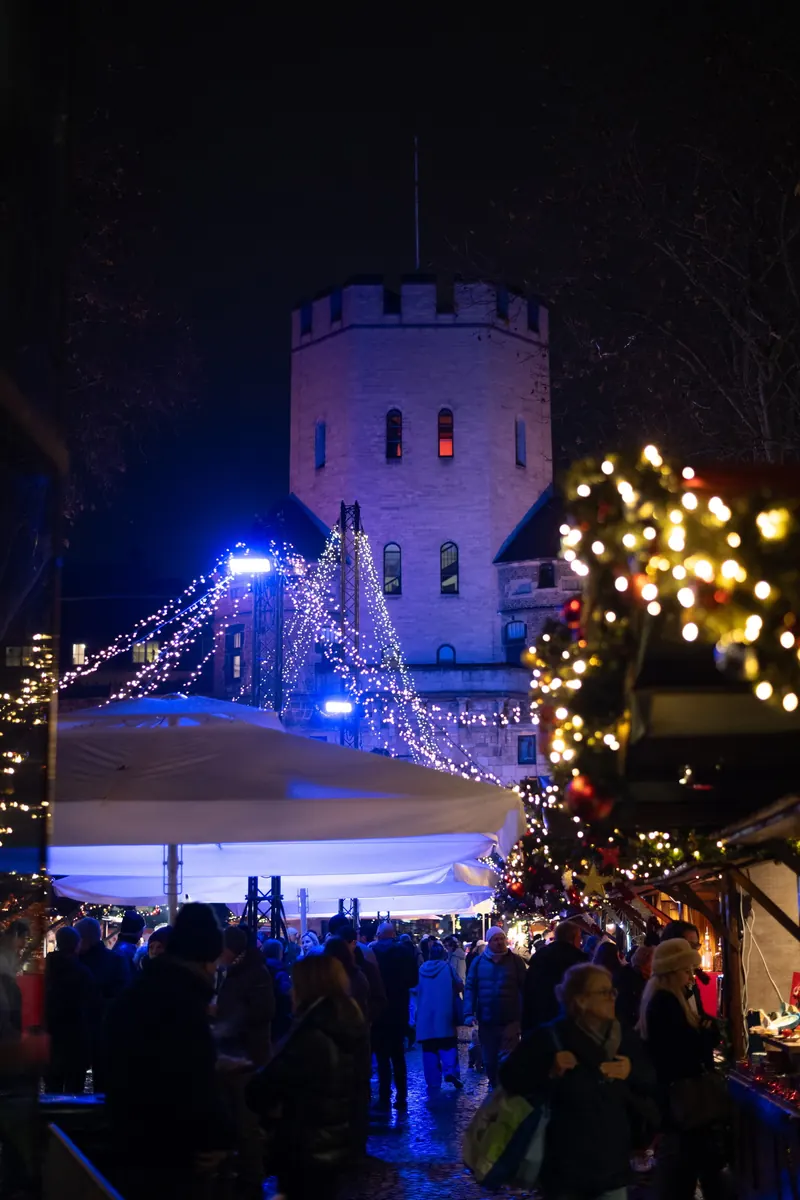 Besucher vor der beleuchteten Severinstorburg bei Nacht